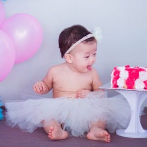 Baby in White Tutu Skirt Beside Cake