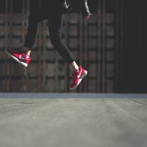 Human in Black Track Pants With Red Nike Sneakers Jumping