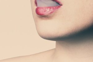 Woman With Red Lipstick Letting Smoke Out from Her Mouth Then Inhales It Again With Her Nose