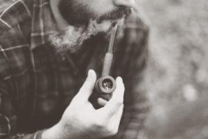 Grayscale Photo of Man Holding Tobacco Pipe