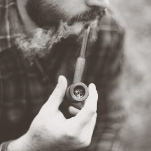 Grayscale Photo of Man Holding Tobacco Pipe