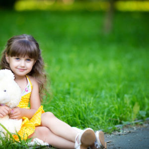 Cute Little Girl Is Wearing Yellow Dress Sitting On Green Grass In Blur Green Background With Teddy Toy HD Cute Wallpapers