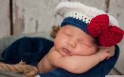 Cute New Born Baby Is Sleeping Dark Blue Satin Towel Wearing Woolen Knitted White Red Cap HD Cute Wallpapers