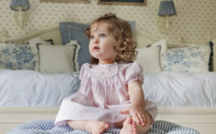Cute Ash Eyes Baby Girl Is Sitting On Bed Wearing Pink Dress HD Cute