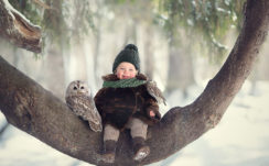Cute Baby Boy Is Sitting On Tree Trunk With Owl Wearing Woolen Muffler And Cap And Brown Soft Jerkin HD Cute