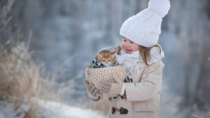 Cute Little Girl Is Holding Kitten In Woolen Basket Wearing Woolen Knitted Cap And Scarf In Show Background HD Cute