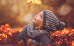 Cute Little Girl Is Lying Down On Dry Leaves Looking Up Flying Leaf Wearing Ash Woolen Knitted Cap And Dress HD Cute Wallpapers