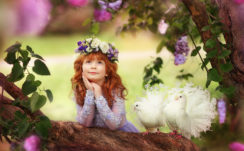 Little Cute Girl Is Holding Face With Hand Looking Up Leaning On Tree Trunk With Pigeon Nearby Wearing Redhead Wreath HD Cute