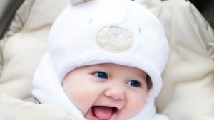 Blue Eyes Cute Baby Is Wearing White Dress And Cap Cute