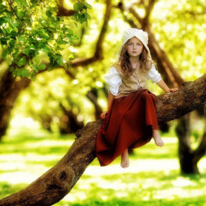 Cute Little Girl Is Sitting On Tree Branch Wearing Red White Dress In Blur Forest Background HD Cute Wallpapers