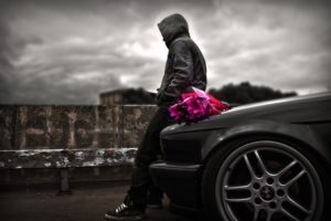 Romantic man waiting the perfect girl with flowers-Black car